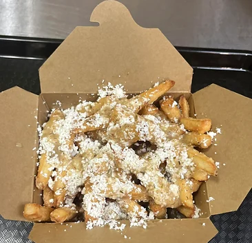 Fries topped with gravy and grated cheese in an open kraft takeout box